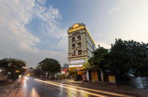 um edifício alto com um sinal numa rua em TheKing Hotel em Hương Gia