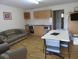 a living room with a table and a couch at Warrnambool Motel and Holiday Park in Warrnambool