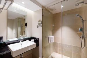 a bathroom with a shower, sink, and toilet at Eastin Hotel Penang in Bayan Lepas