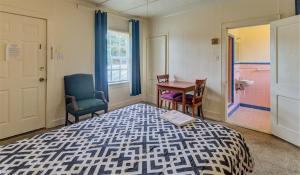 a bedroom with a bed and two chairs and a table at ASAM HOTEL in Vicksburg