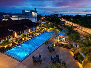 a hotel room with a pool and chairs at Eastin Hotel Penang in Bayan Lepas