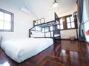 a bedroom with two bunk beds and a wooden floor at Pool villa 3 BR 10 Persons 5-min to tiger zoo - Njoy Pool villa in Si Racha