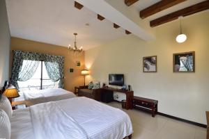 a large bedroom with two beds and a television at Ji Li Ya Lan Villa in Chenggong