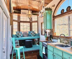 una cocina con armarios verdes y un banco en el centro en Zions Tiny Oasis, en Virgin