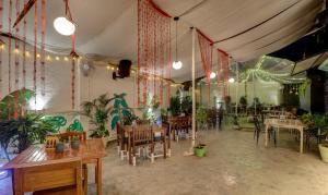 Treebo Trend Ranjeet Shivaji Nagar في بيون: مطعم بطاولات وكراسي في غرفة بها نباتات