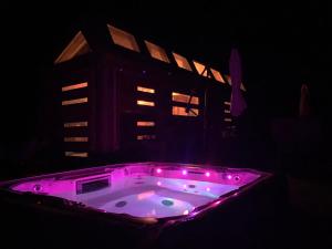 a hot tub with pink lights in front of a building at Zions Tiny Oasis in Virgin