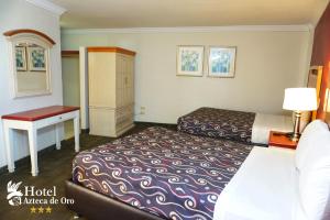 a hotel room with a bed and a desk at Hotel Azteca de Oro Mexicali in Mexicali