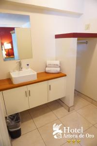 a bathroom with a sink and a mirror at Hotel Azteca de Oro Mexicali in Mexicali