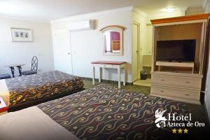 a hotel room with a bed and a flat screen tv at Hotel Azteca de Oro Mexicali in Mexicali