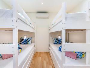 a room with four bunk beds in a house at Oceanview in Port Fairy