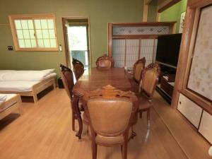 a dining room with a wooden table and chairs at Shirahama Meiji Villa in Shirahama
