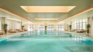 a large swimming pool in a building with a ceiling at Hyatt Regency Ningbo Hangzhou Bay in Ningbo