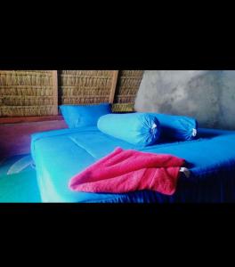 uma cama azul com um cobertor rosa e almofadas azuis em Alengkong Double View em Kintamani