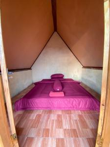 uma pequena cama rosa num pequeno quarto em Alengkong Double View em Kintamani