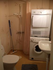 ein Badezimmer mit einer Waschmaschine und einem Waschbecken in der Unterkunft Karaby Gård in Kristinehamn