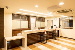 a kitchen with a counter and stools in a room at Kyoto Central Inn in Kyoto