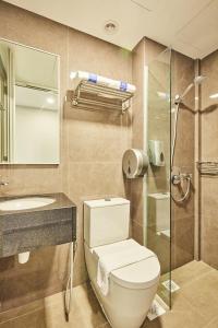 La salle de bains est pourvue de toilettes, d'un lavabo et d'une douche. dans l'établissement ibis budget Singapore Ametrine, à Singapour