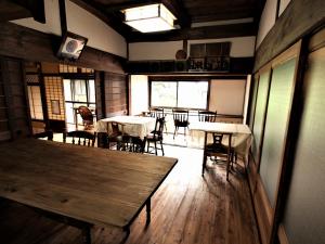 uma sala com mesas e cadeiras num restaurante em ゲストハウス喜平 em Kaizuka
