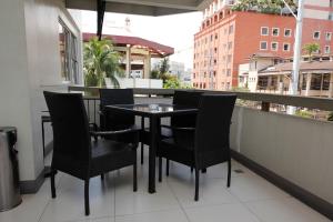 una mesa negra y sillas en el balcón en Casa Pura Inn and Suites en Manila