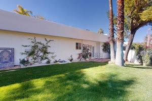 una casa blanca con palmeras en un patio en The Alhambra Permit# 4587, en Palm Springs