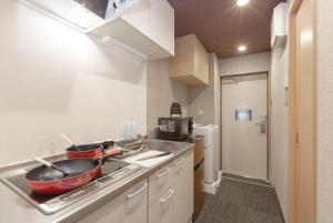 a small kitchen with a sink and a stove at Stay SAKURA Kyoto Kiyomizu Gojo in Kyoto