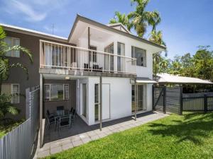 a white house with a balcony and a yard at Reef Terraces on St Crispins in Port Douglas