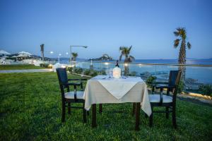 a table with a white table cloth and two chairs at Royal Bay Suites in Kefalos