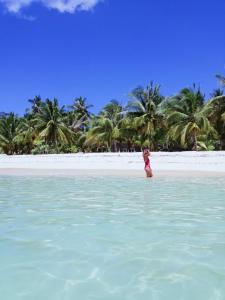 盧納將軍城的住宿－Anajawan Island Beachfront Resort，站在海滩上水面上的女人