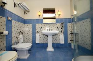 Un baño azul con inodoro y lavabo. en La Pecora Ladra Appartamenti, en Montalto di Castro 28 fotos más