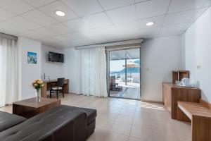 salon z kanapą i stołem w obiekcie Royal Bay Suites w mieście Kefalos