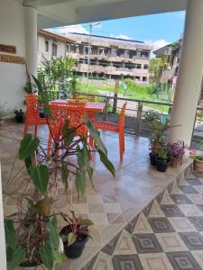 a patio with a red table and chairs and plants at Sushils Bed and Breakfast in Port Blair