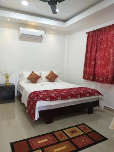 a bedroom with a bed with a red curtain at Sushils Bed and Breakfast in Port Blair