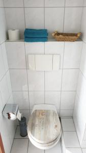 a white tiled bathroom with a toilet in a room at Appartement mit Weitblick in Mönchengladbach