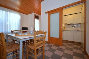 eine Küche und ein Esszimmer mit einem Tisch und Stühlen in der Unterkunft Villa Beethoven in Lignano Sabbiadoro