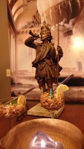 Una statua di un uomo che tiene una bacchetta e una candela di Buiten Huisje aan de Vaart 1 a Matsloot