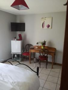 a bedroom with a desk and a table with two chairs at Chambre d'Hôtes Spincourt 2 personnes in Spincourt