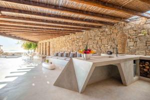 a kitchen with a sink and a stone wall at Villa Fleur De Sel in Fanari
