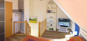 ein Wohnzimmer mit einer Treppe, einem TV und einer Treppe in der Unterkunft Ferienhaus Marina in Boltenhagen