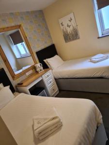 a hotel room with two beds and a mirror at The Avenue Club and Lodge in Birmingham