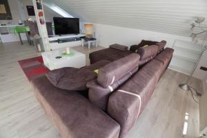 sala de estar con sofá de cuero marrón en Ferienwohnung in Süddeutschland (D-CH-F), en Fischingen