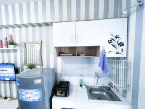 La cuisine est équipée d'un évier et d'un réfrigérateur. dans l'établissement Green Bay Pluit Apartment - Seaview Studio Fast Wifi, à Jakarta