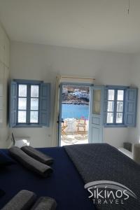 a bedroom with a bed with a view of the water at Seaside Traditional Cycladic House in Sikinos