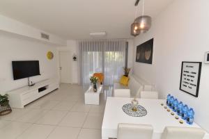 a living room with a couch and a tv at דירת גן דלוקס-Deluxe Garden Apartment by CRWON in Eilat