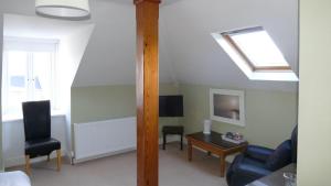 a living room with a skylight and a couch and a table at Avonmore House in Youghal