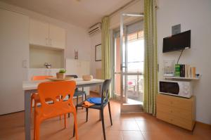 una cucina con tavolo, due sedie e un tavolo di Residenza Casa Mare a Lignano Sabbiadoro