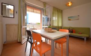 a dining room with a table and orange chairs at Residenza Casa Mare in Lignano Sabbiadoro