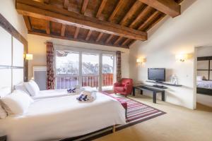 a hotel room with two beds and a television at Hôtel Club MMV Les 2 Domaines in Belle Plagne