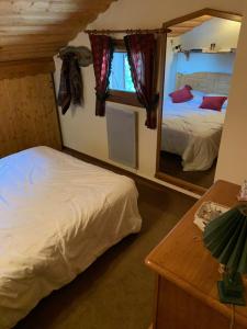 um quarto com 2 camas e um espelho em Bel appartement au décor Montagnard - 80m2 em Les Contamines-Montjoie