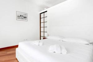 ミラノにあるPagano & Cenacolo Bright Apartmentの白いベッド(白いシーツ、枕付)