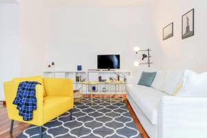ミラノにあるPagano & Cenacolo Bright Apartmentのリビングルーム(白いソファ、黄色い椅子付)